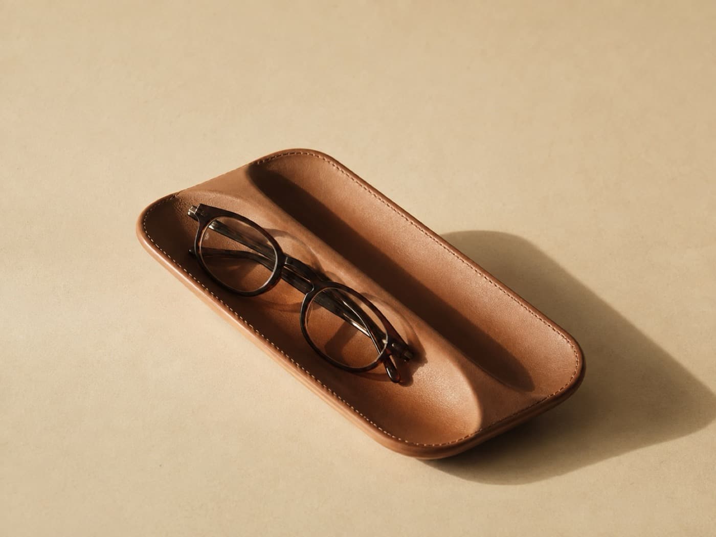Remote & Glasses Caddy — Two moulded channels side by side. One for what you read with, one for what you press.